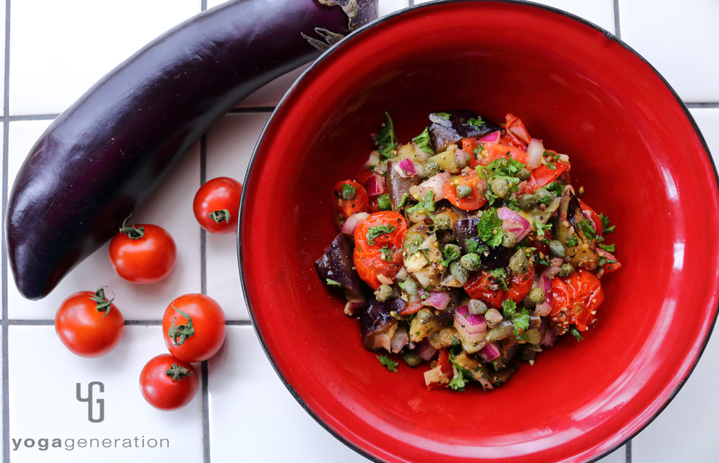 赤の皿に盛りつけたケイパーを効かせたナスとトマトのマリネ