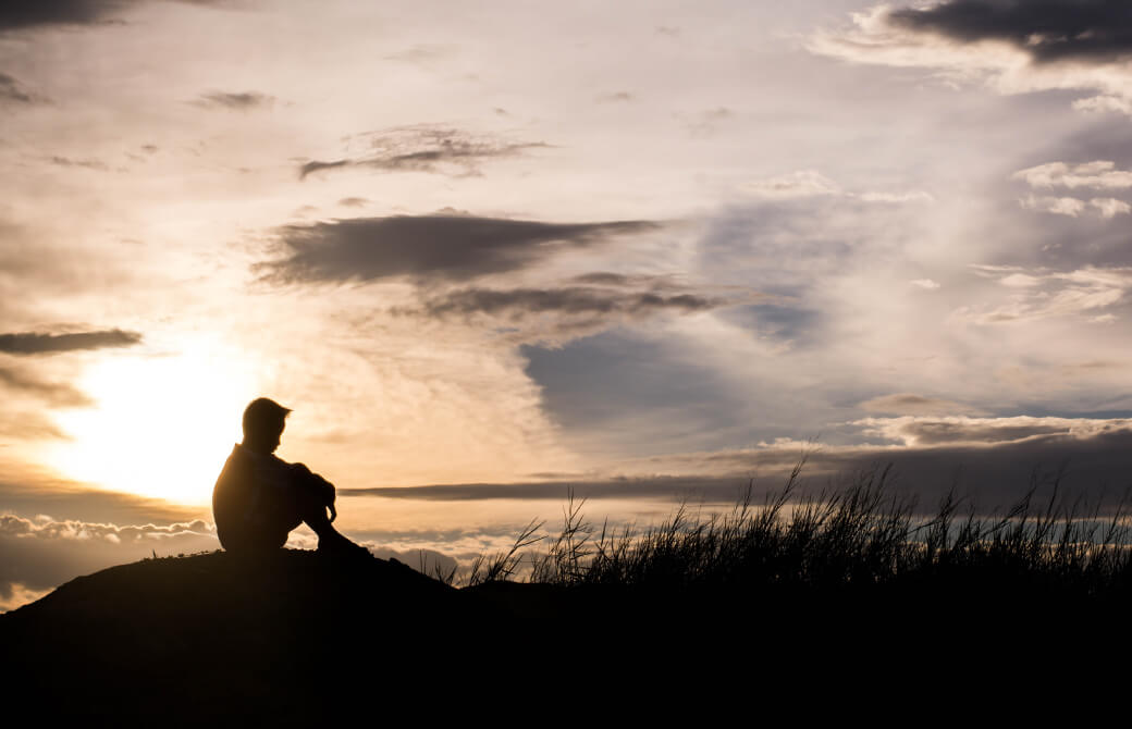 岸辺にたたずみ海を眺める少年