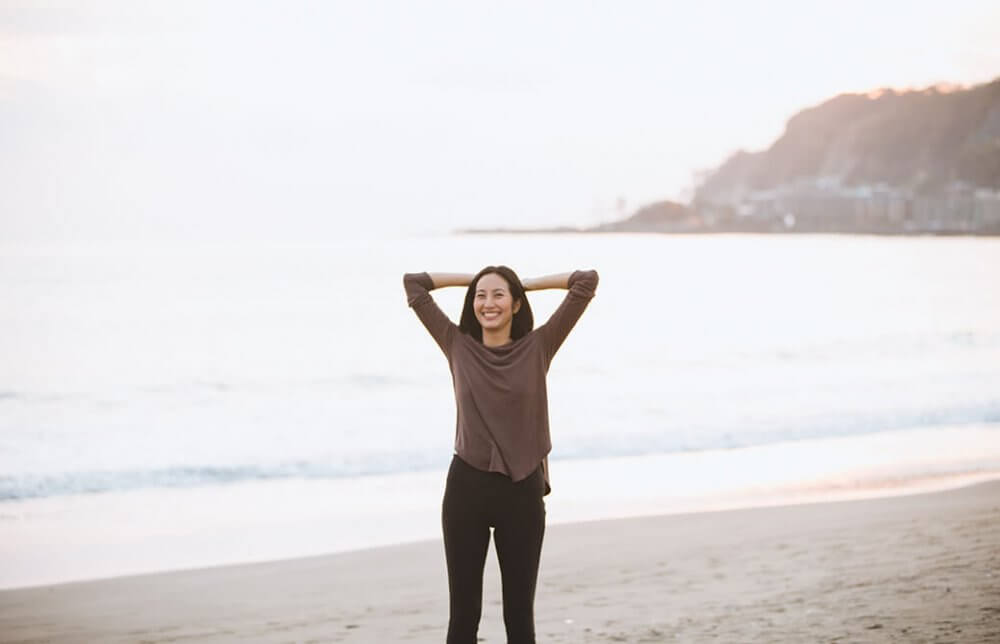 浜辺で笑顔を見せるサンートシマ香先生