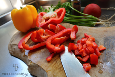 赤いパプリカをまな板で切る