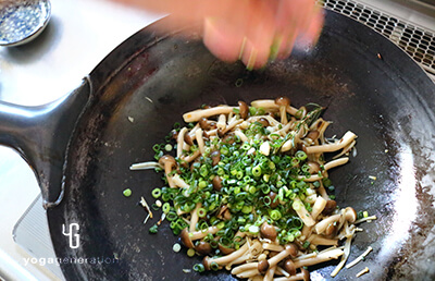 炒めたキノコに細ネギをたっぷりかける