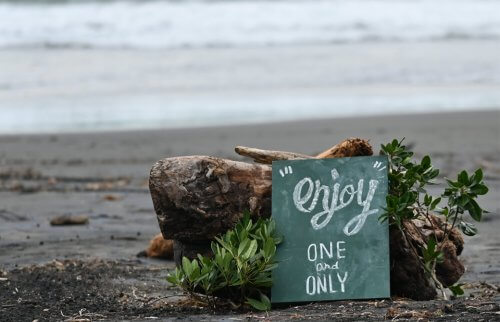 今井浜にenjoyONEandONLYと書かれた黒板が置かれている