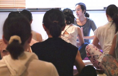 大勢の生徒さんの前でヨガを指導するサントーシマ香