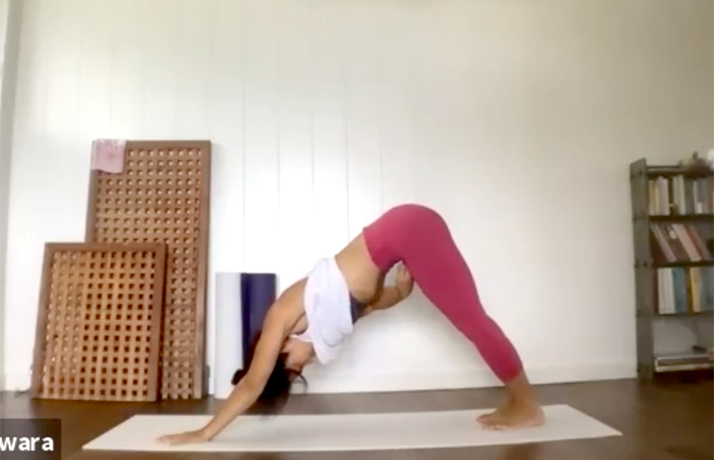 ヨーコ先生がバンダの説明をしながらダウンドッグをしている