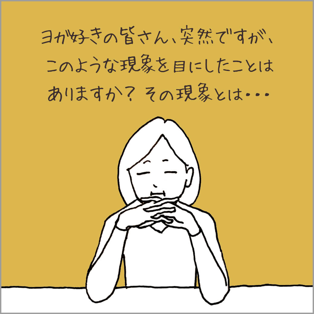 机に肘をついて座る主人公