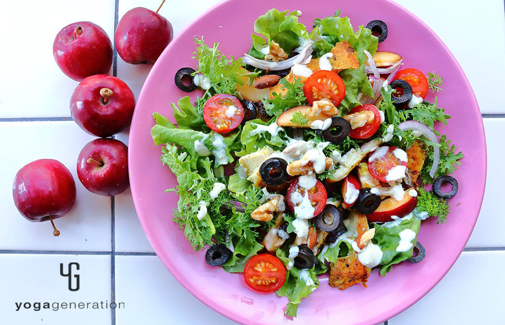 ピンクのお皿に盛り付けたスパイシーチキンとフレッシュなリンゴのサラダ