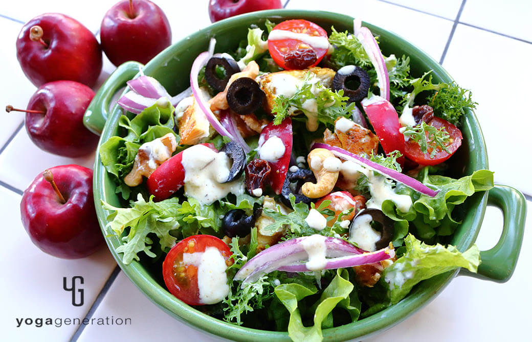 緑のお皿に盛り付けたスパイシーチキンとフレッシュなリンゴのサラダ