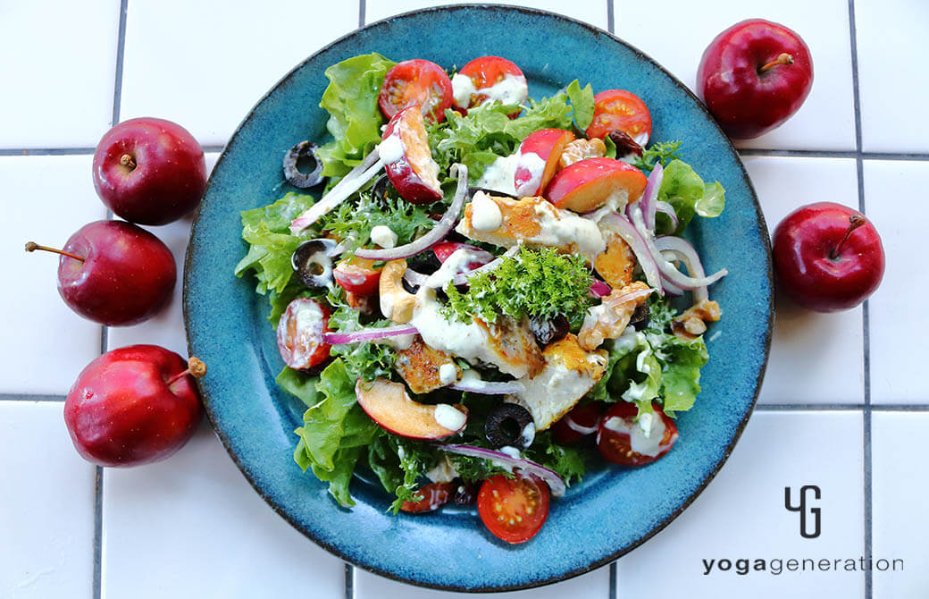 ターコイズのお皿に盛り付けたスパイシーチキンとフレッシュなリンゴのサラダ