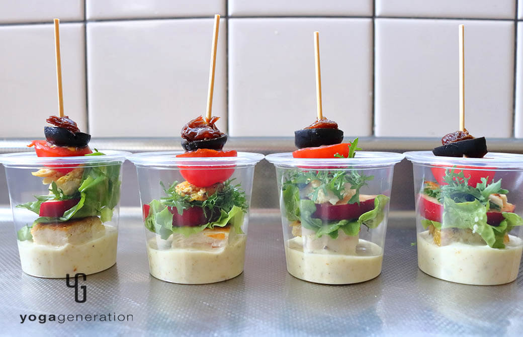 ピンチョスをカップに盛りつけたスパイシーチキンとフレッシュなリンゴのサラダ