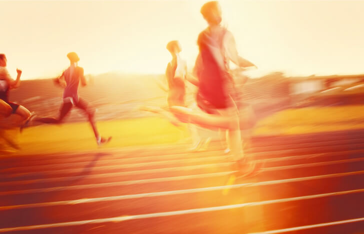 陸上トラックを走る若者たち