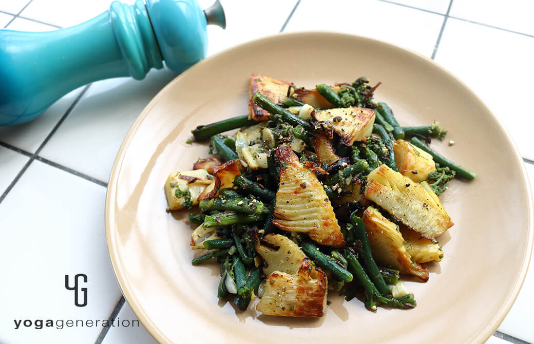 ベージュのお皿に盛り付けたタケノコとワラビのガーリック炒め