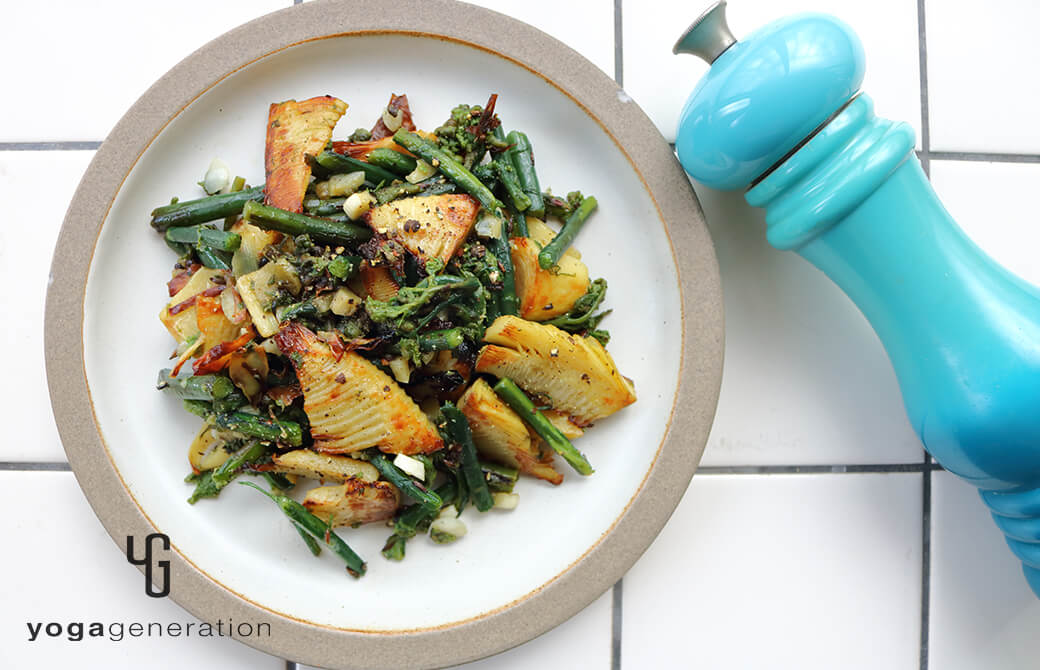 白いお皿に盛り付けたタケノコとワラビのガーリック炒め