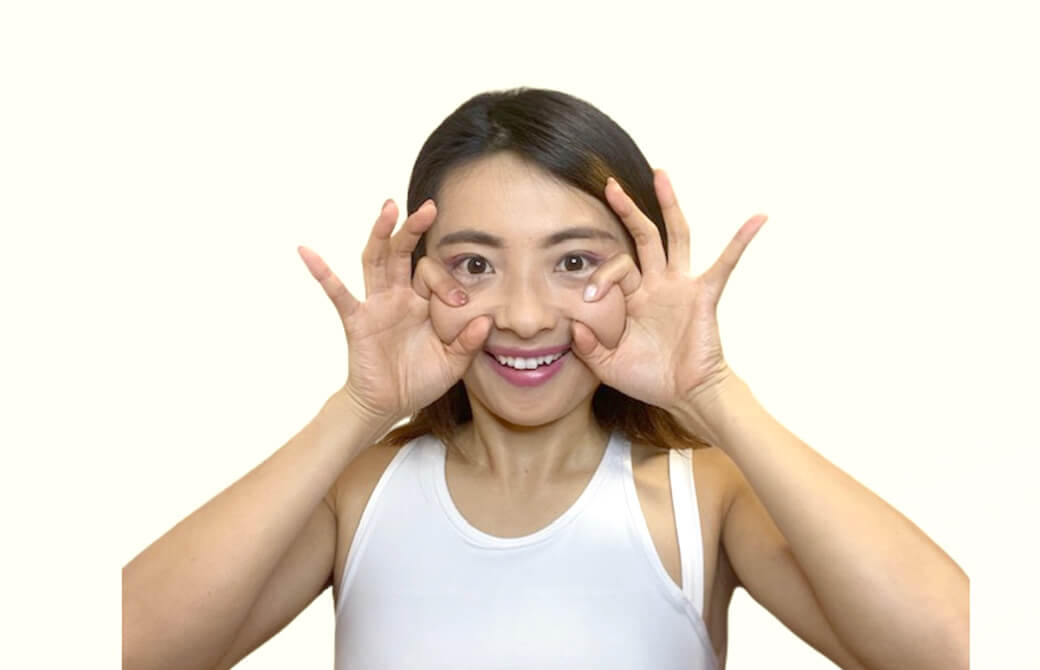 OKマークで頬のおだんごを持ち上げる