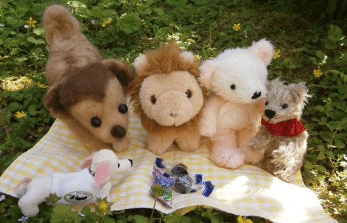 草の上の布に並んだぬいぐるみたち