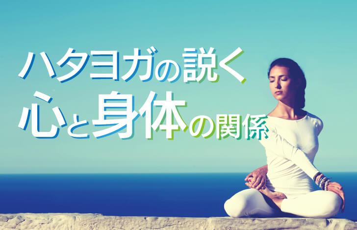 海辺でヨガのねじりのポーズをする女性