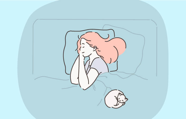 ベッドで眠る女性と猫