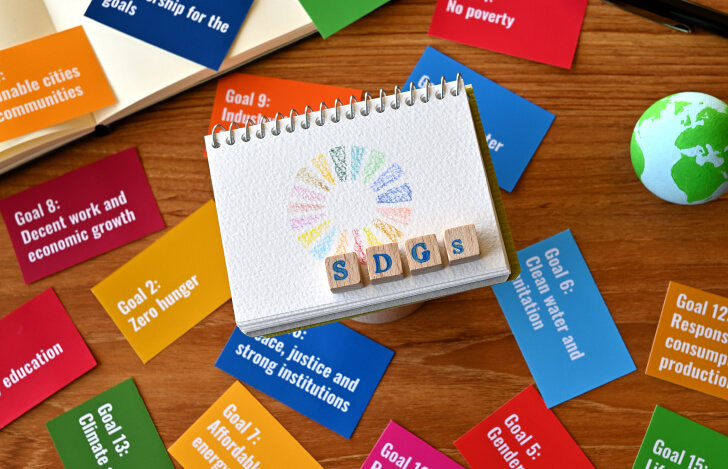SDGsの文字と17の課題の書かれた色とりどりのカード