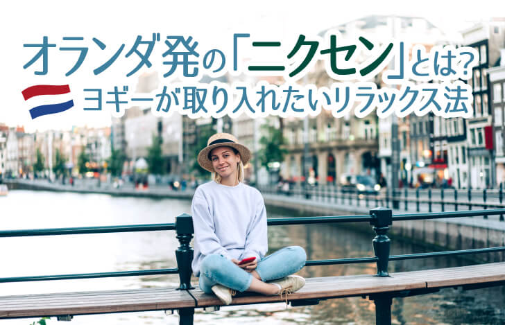 街の中を流れる川沿いに座る女性