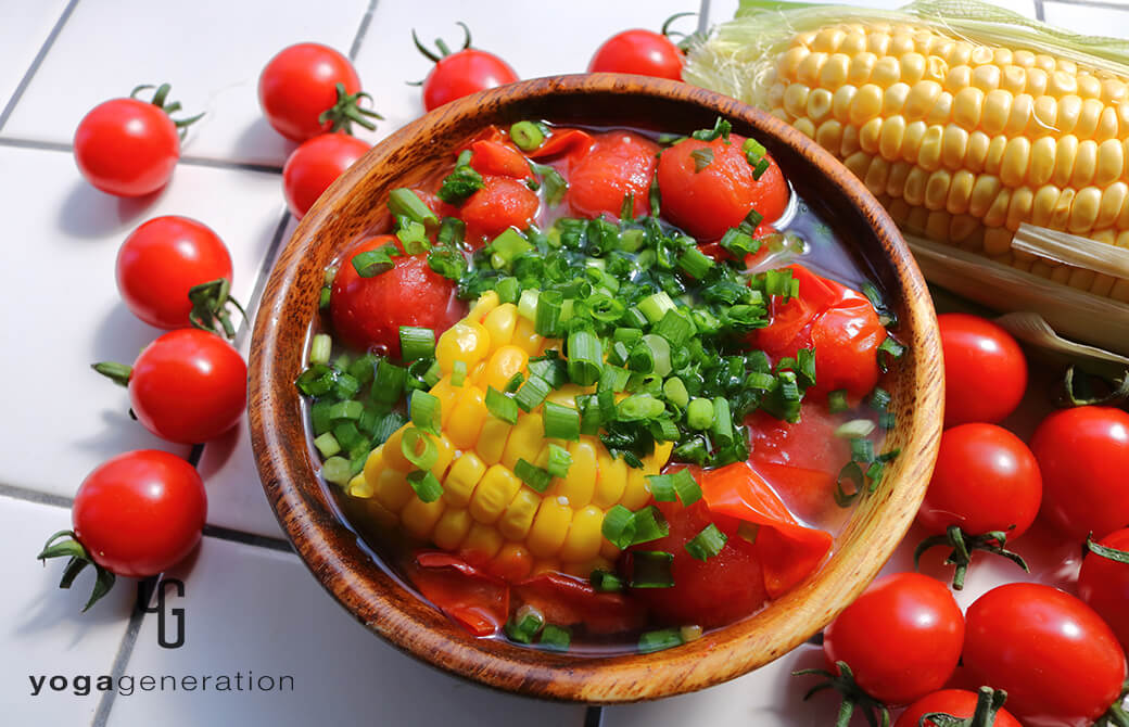 木の器に盛り付けたトウモロコシとトマトのお味噌汁