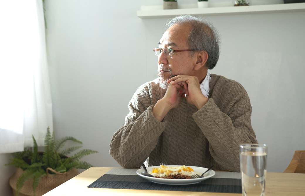 1人で食事をしている老齢の男性