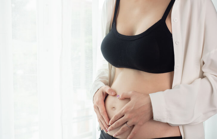 お腹に手を当てる妊娠中期の妊婦
