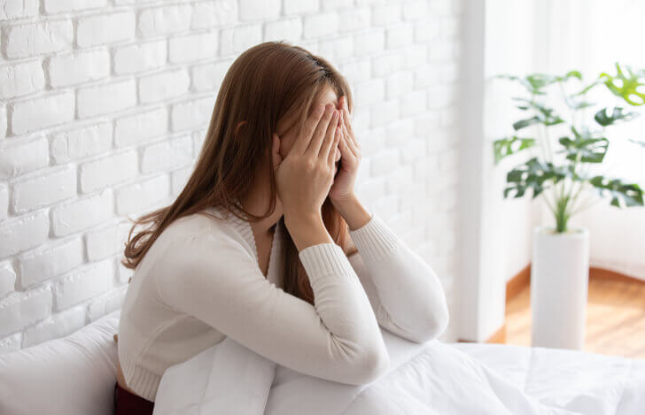 頭を抱えて悩む女性