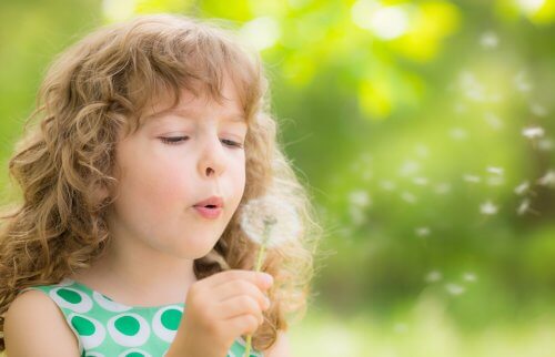 タンポポを吹く子ども