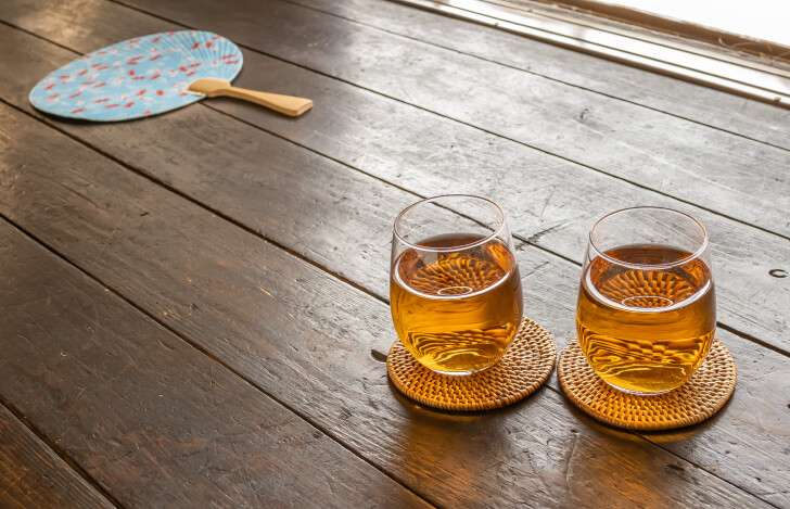 グラスに入った麦茶とうちわ