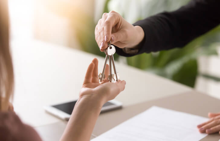鍵の受け渡しを行う人の手