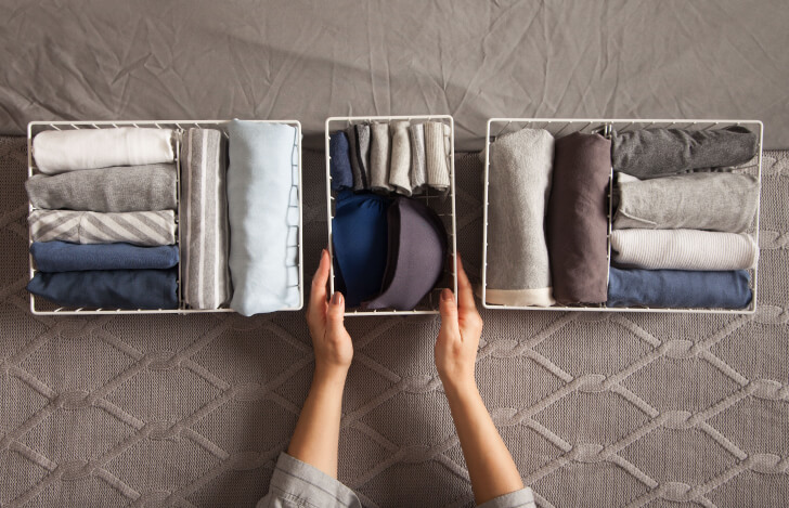 丁寧に収納ボックスにタオルをしまう人の手
