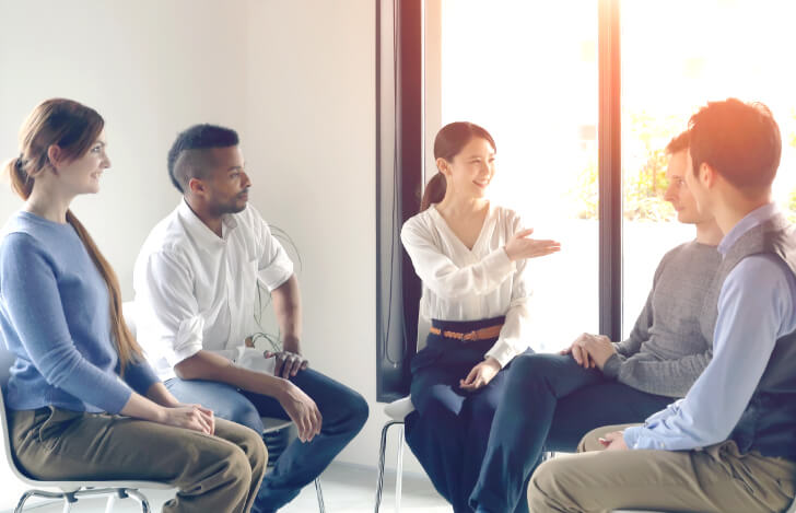 外国人の人々の中心で語る日本人女性
