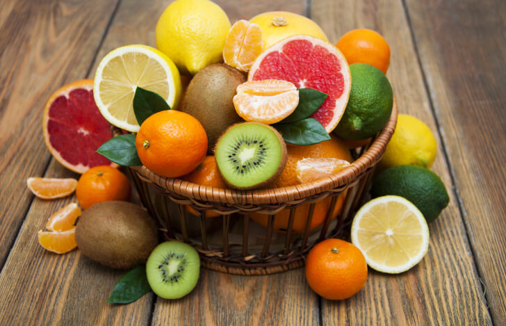 カゴに盛られた柑橘系の果物とキウイ