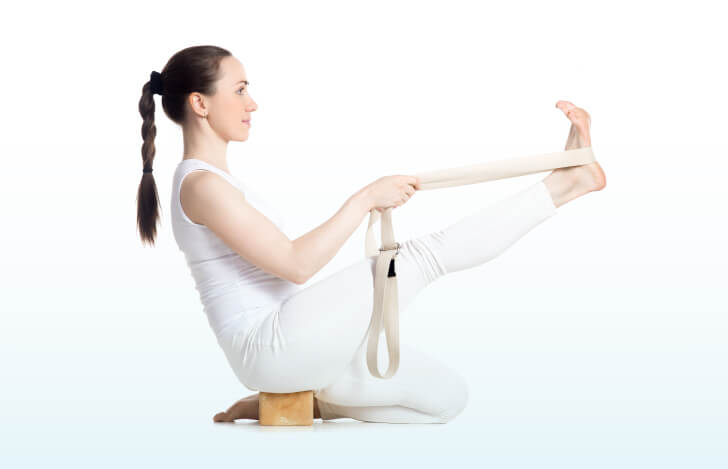 プロップスを使ってアーサナをとる若い女性