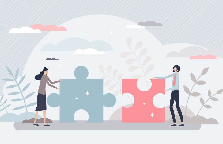 大きなパズルのピースを持った男女