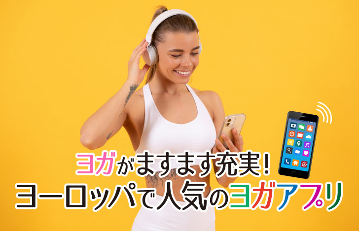 ヘッドフォンとフィットネスウェアを身につけスマホアプリを見る女性