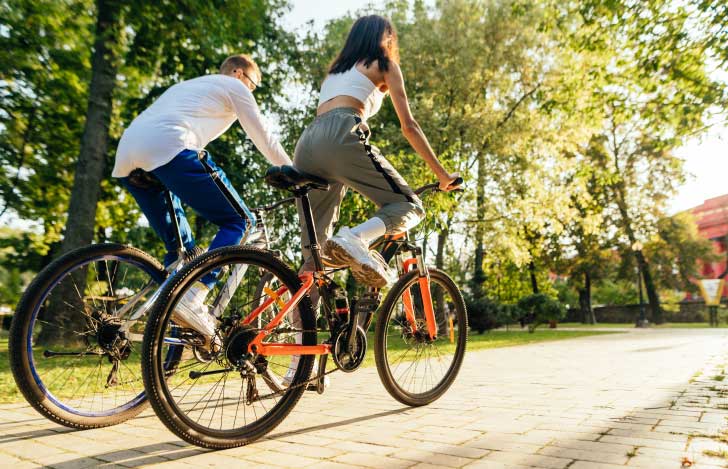 サイクリングをしている男女の後ろ姿