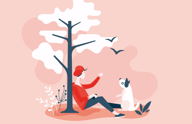 木の根元でくつろぐ少年と犬