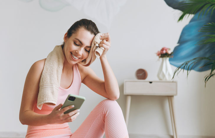 スマホを見ながらヨガを楽しむ女性