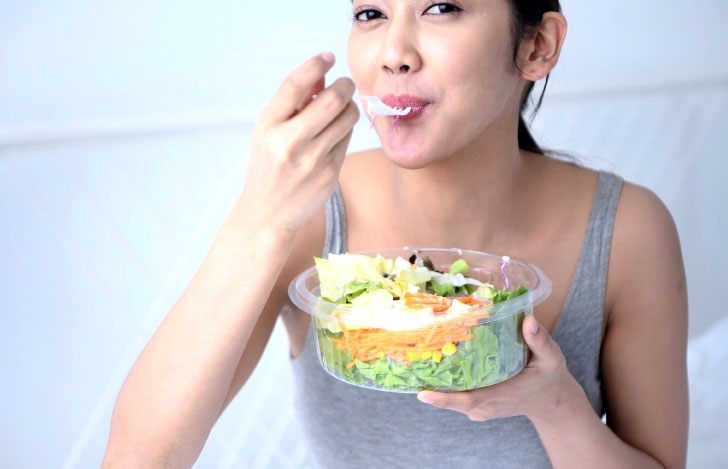 サラダを食べる女性