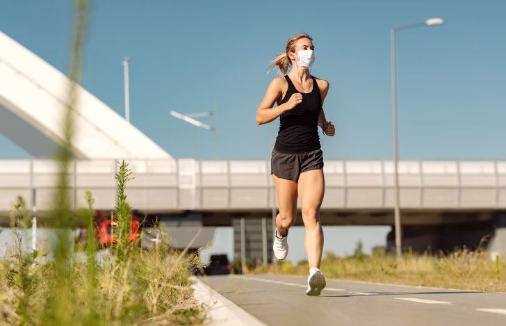 マスクをつけて外を走るランニングウェアの女性