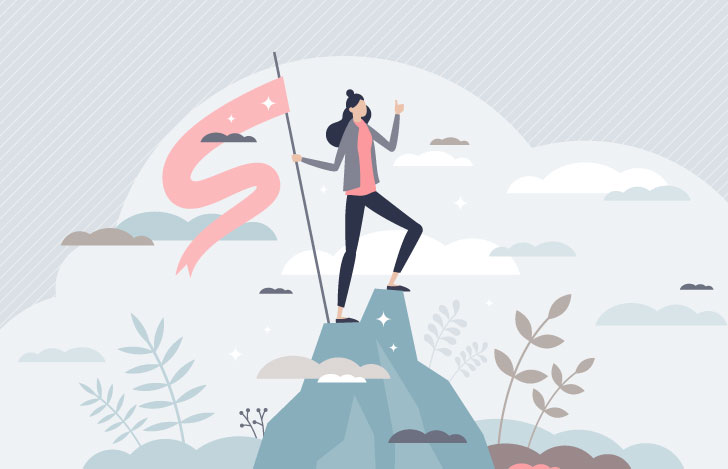 山の頂上で旗を持つ女性