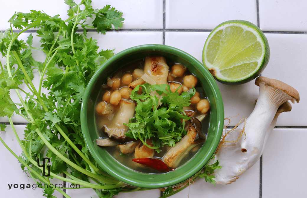 緑のお皿に盛り付けたヒヨコ豆とエリンギの酸っぱスパイシースープ