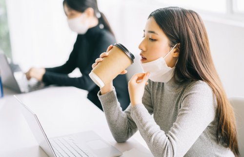 マスクを外して珈琲を飲む女