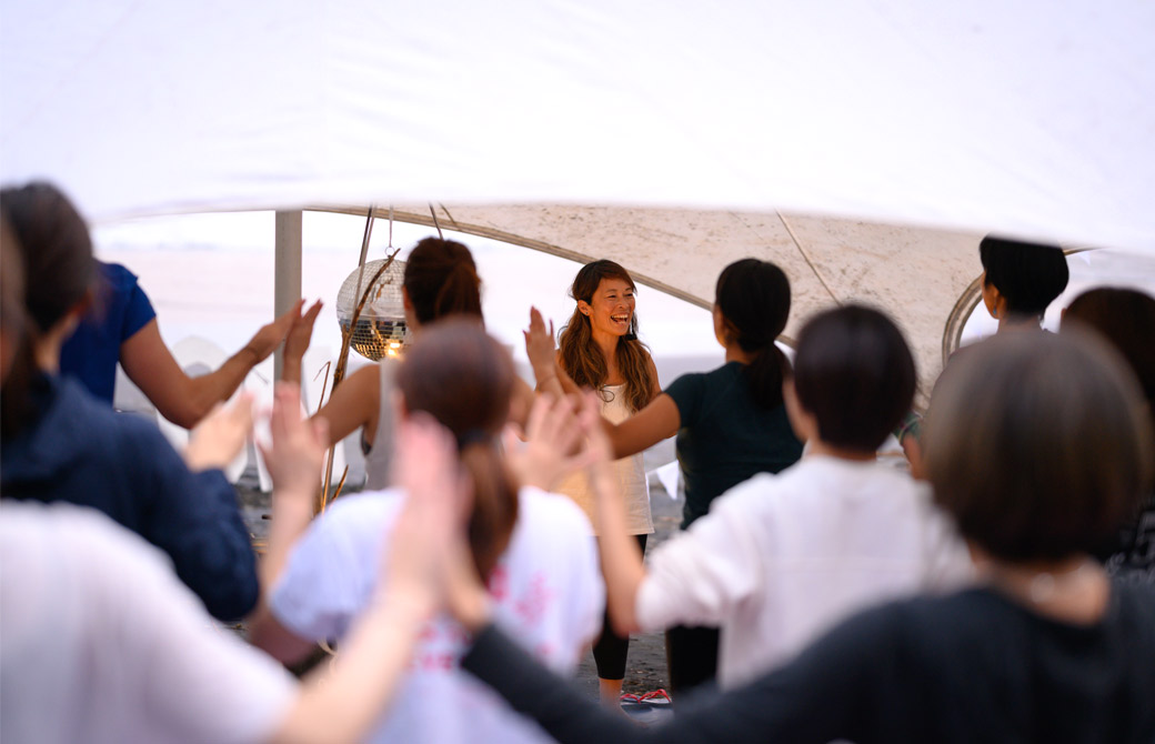 マイコ先生がたくさんの生徒さんの前でヨガをしている