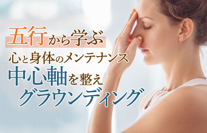 眉間に指をあて目を閉じる女性の横顔