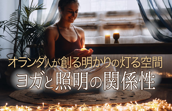 キャンドルを手に薄暗い部屋でヨガをする女性