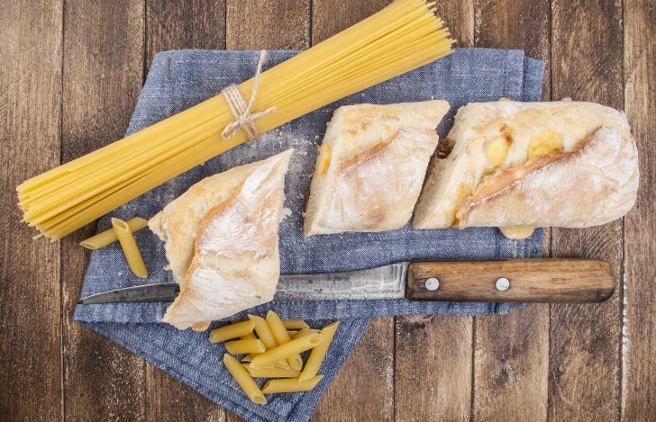 テーブルに置かれたパスタとパンとナイフ