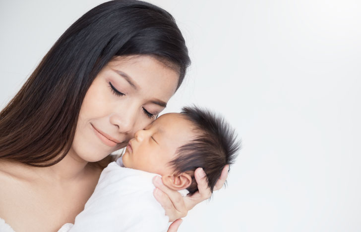 生まれたばかりの赤ちゃんに頬擦りをする母親