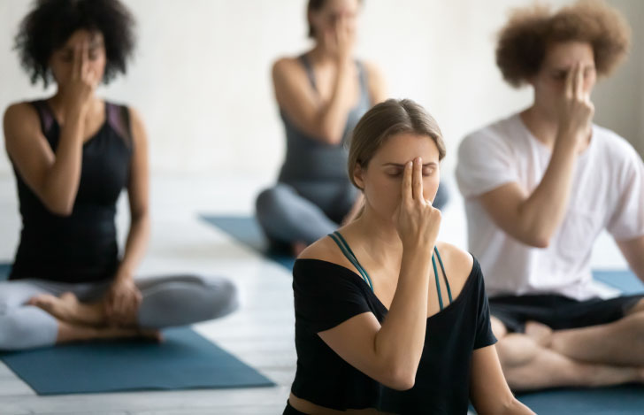 ヨガのクラスで呼吸法をする人々