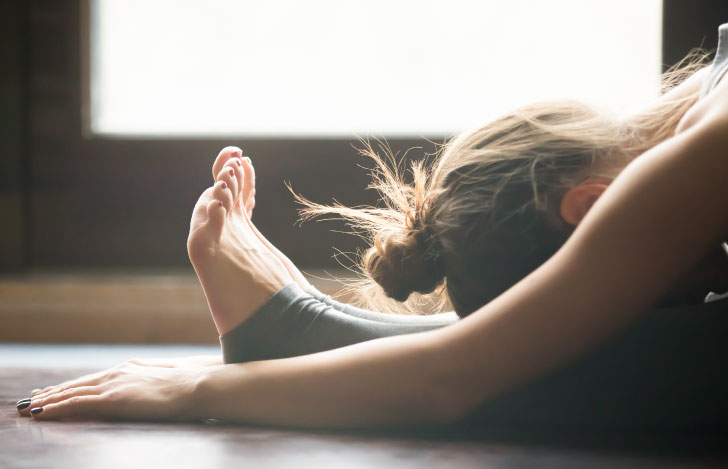 前屈をする女性の頭部と足元